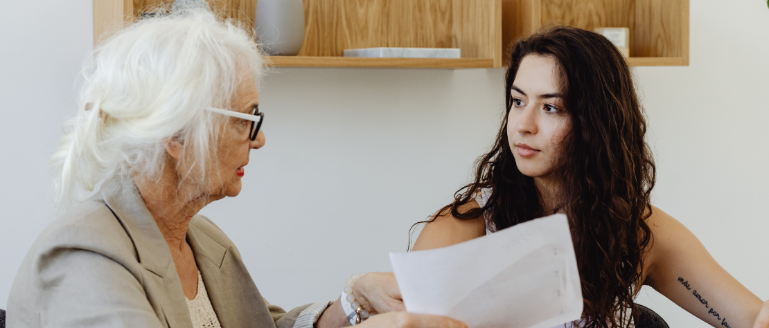 Seniorin mit weißen Haaren spricht mit einer jungen Dame