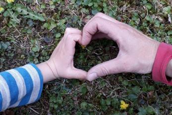 Herz geformt auf einer Kinder- und Erwachsenenhand